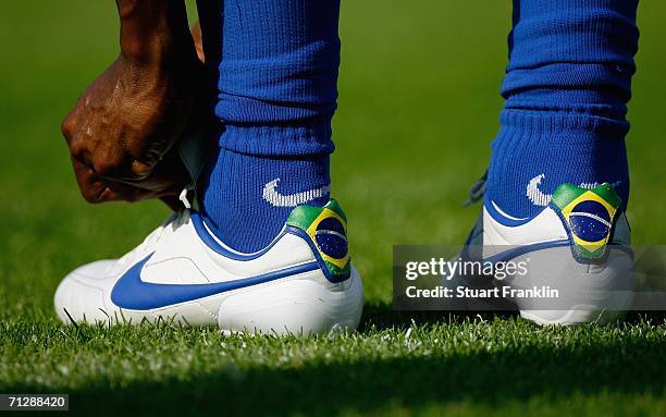 Gilberto of Brazil does up the laces of his boots during the Brazil National Football Team training session for the FIFA World Cup Germany 2006 at...