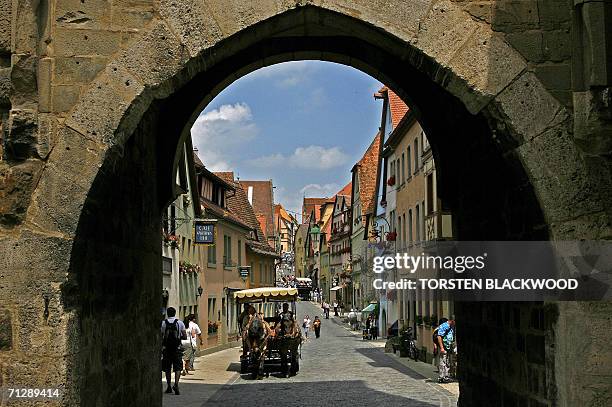 Rothenburg ob der Tauber, GERMANY: A horse-drawn cart still ferries people along the cobblestoned Obere Schmiedgasse through the medieval city of...