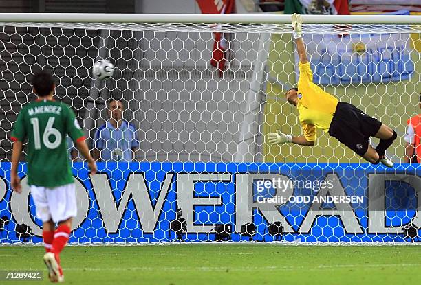 Mexican goalkeeper Oswaldo Sanchez dives vainly to save a kick by Argentinian midfielder Maxi Rodriguez during the World Cup 2006 round of 16...