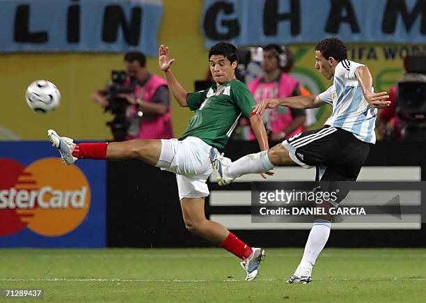 Argentinian midfielder Maxi Rodriguez volley the ball to score a goal despite Mexican defender Gonzalo Pineda during the extra time of the World Cup...