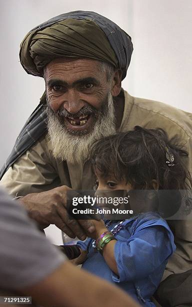 Afghan patients speak with a U.S. Army medic at an American military clinic on June 25, 2006 in Deh Afghan in the Zabul province of Afghanista. Army...