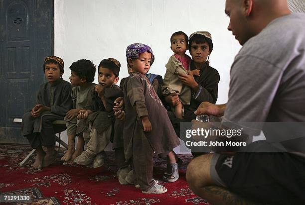 Army medic Spc. Travis Dietz dispenses medication to young Afghan patients at an American military clinic on June 25, 2006 in Deh Afghan in the Zabul...