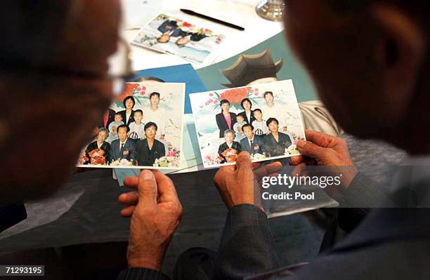 North Korean Hwang Kum-Yop , looks at family photo with his South Korean relative Hwang Sung-Hyup during the third round of the 14th Separated Family...