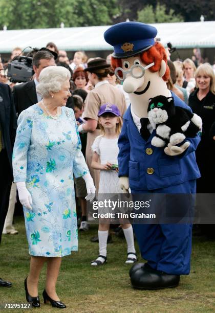 Queen Elizabeth II meets Postman Pat and his black and white cat, Jess, amongst other storybook characters at the Children's Party at the Palace, a...