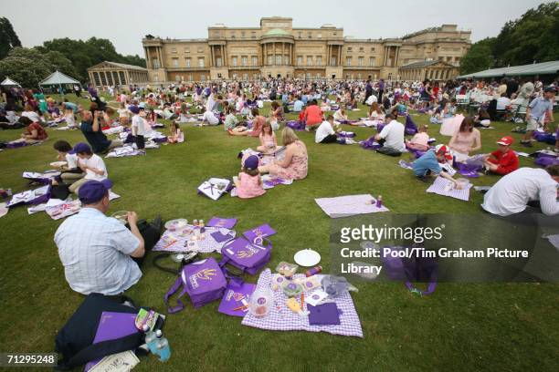 Children and parents picnic at the Children's Party at the Palace, a children's literacy garden party to celebrate the Queen's 80th birthday at...