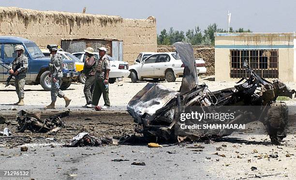 Soldiers stand guard at the site of a suicide attack near the main US base in Afghanistan at Bagram, some 50 kms north of Kabul, 26 June 2006. A...