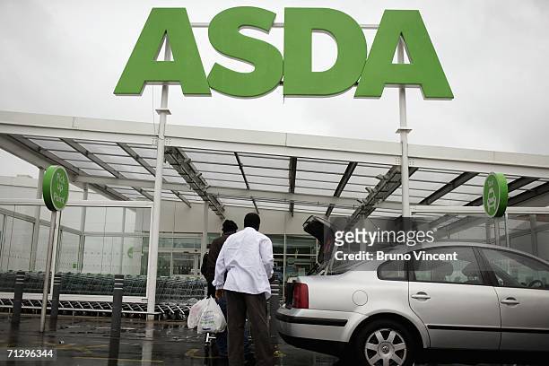 Customers leave an ASDA superstore with their goods on June 26, 2006 in London, England. Thousands of Asda depot workers are due to strike for five...