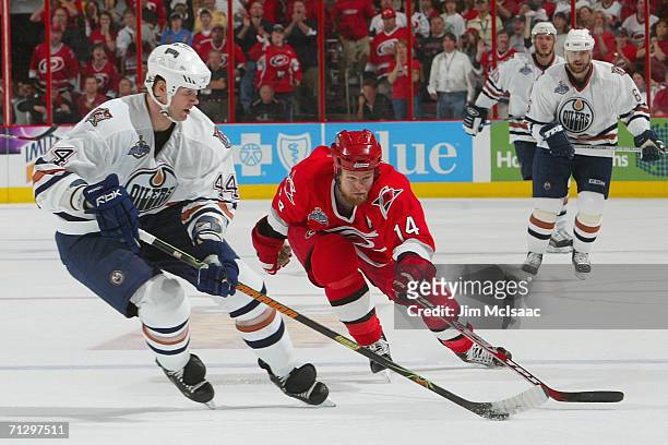 Chris Pronger of the Edmonton Oilers controls the puck against Kevyn Adams of the Carolina Hurricanes during game seven of the 2006 NHL Stanley Cup...