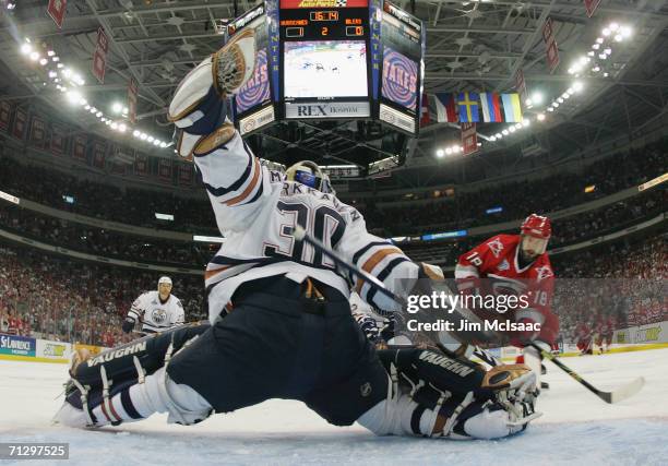 Jussi Markkanen of the Edmonton Oilers makes a save against Mark Recchi of the Carolina Hurricanes during game seven of the 2006 NHL Stanley Cup...