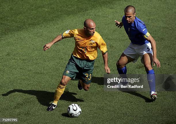 Marco Bresciano of Australia is challenged by Fabio Cannavaro of Italy during the FIFA World Cup Germany 2006 Round of 16 match between Italy and...