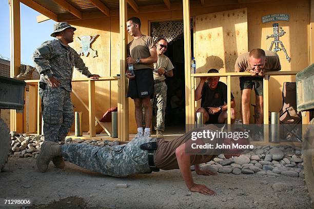 Army Pv2 Kristopher Pruett from the 2nd Battalion, 4th Infantry Regiment is ordered to do push ups at an American base June 26, 2006 at Deh Afghan in...
