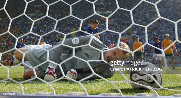 Kaiserslautern, GERMANY: Australian goalkeeper Mark Schwarzer looks at the ball after giving up the winning goal on a penalty kick scored by Italian...