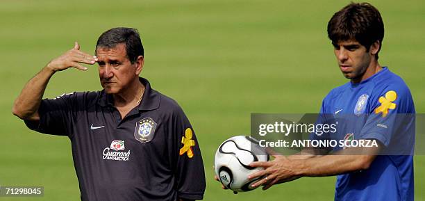 Bergisch Gladbach, GERMANY: Brazilian midfielder Juninho holds a ball while head coach Carlos Alberto Parreira watches his players during a training...