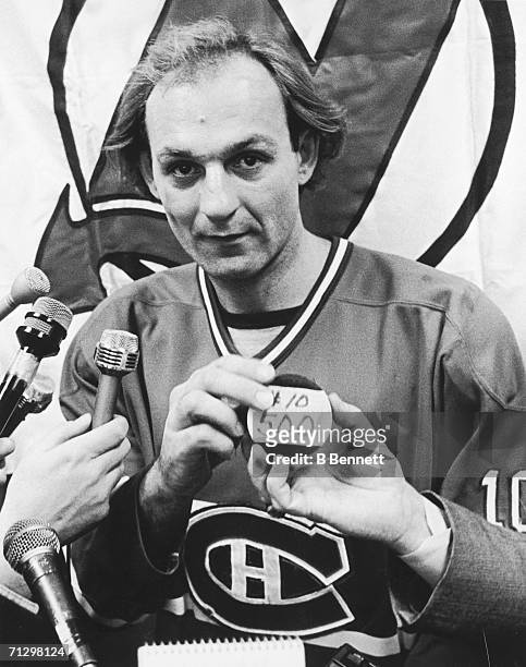 Canadian hockey player Guy Lafleur of the Montreal Canadiens poses holds the puck with which he scored his 500th career goal during a game against...