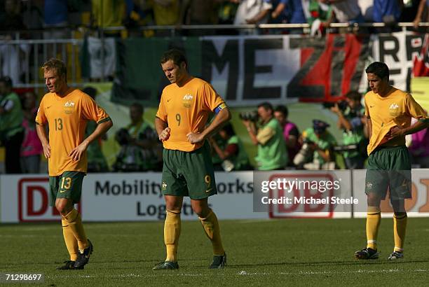 Dejected Australians, Vince Grella , Mark Viduka and Tim Cahill look on following their team's 1-0 defeat and exit from the competition during the...