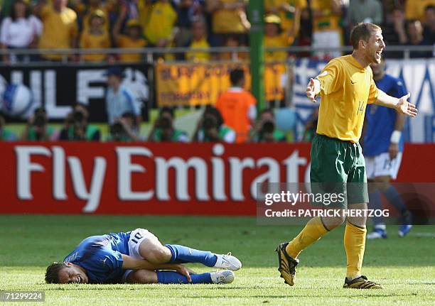 Kaiserslautern, GERMANY: Italian midfielder Francesco Totti grimaces while holding his leg as Australian defender Scott Chipperfield protests during...