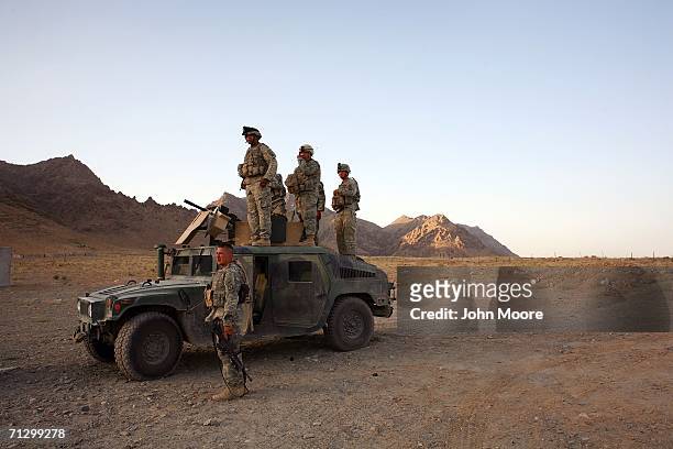 American soldiers from the 2nd Battalion, 4th Infantry Regiment watch as soldiers fire their weapons near their base June 26, 2006 at Deh Afghan in...