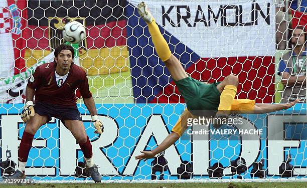 Kaiserslautern, GERMANY: Australian midfielder Tim Cahill tries a scissor-kick as Italian goalkeeper Gianluigi Buffon looks on during the round of 16...
