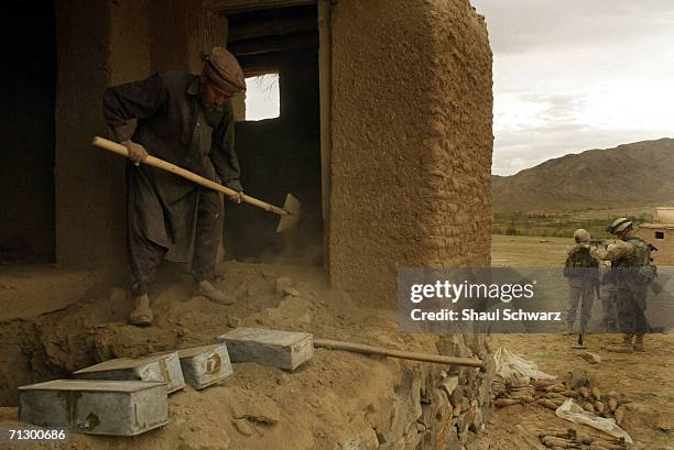 Soldiers, with the help of local Afghans, uncover ammunition yards away from a active school on April 17, 2004 in Ghazni, Afghanistan. Soldiers of...