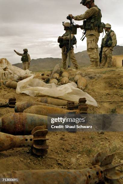 Soldiers with the help of local Afghans uncover ammunition dug in the dirt yards away from an active school on April 17, 2004 in Ghazni, Afghanistan....