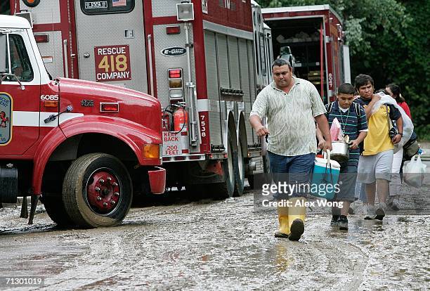 Juan Galvan of Gaithersburg, Maryland, helps his cousin local resident Saul Romero and his nephew Hernandez Noel to evacuate due to a damage in their...