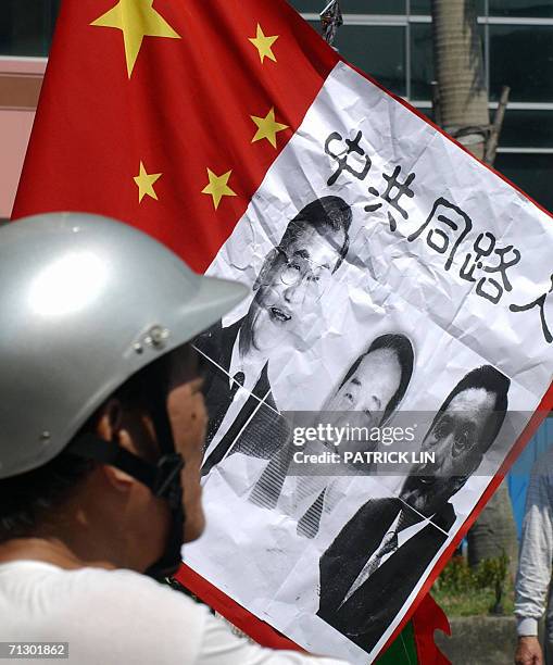 Supporter of President Chen Shui-bian looks at a poster, showing the opposition leaders Lien Chan, James Soong and Ma Ying-jeou, pasted on a Chinese...