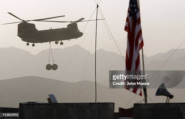 An American Chinook helicopter brings in tanks of aviation fuel to a U.S. Base at Deh Afghan June 27, 2006 in the Zabul province of southern...
