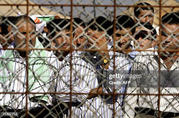 Detainees stand inside the Abu Ghraib prison, west of Baghdad, while waiting to be released in Baghdad, 27 June 2006. About 450 detainees held in US...