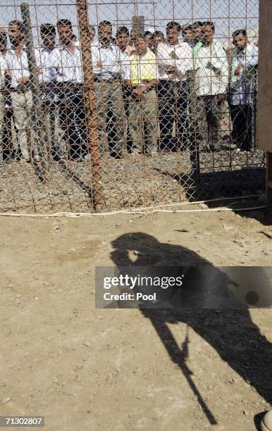 Detainees stand in the Abu Ghraib prison yard while waiting to be released on June 27, 2006 in Baghdad, Iraq. Another 500 detainees were released...