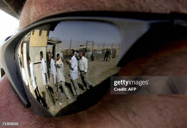 Iraqis leaving the prison are reflected from the sunglasses of a U.S. Soldier at the Abu Ghraib prison, west of Baghdad, 27 June 2006. About 450...