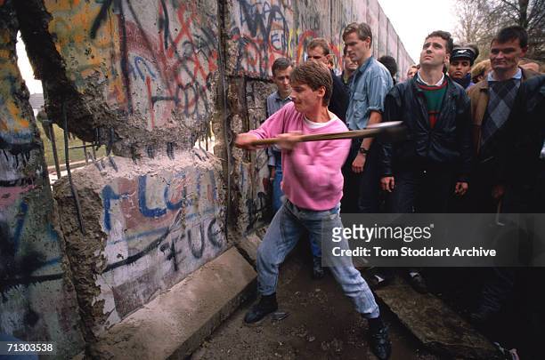 The first section of the Berlin Wall is torn down by crowds near the Brandenburg Gate on the morning of 10th November 1989. The area around the...