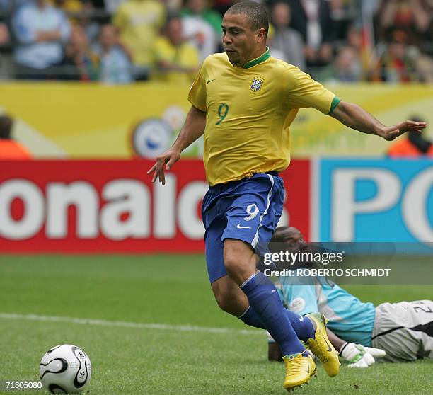 Brazilian forward Ronaldo dribbles the ball past Ghanaian goalkeeper Richard Kingston to score during the round of 16 World Cup football match...