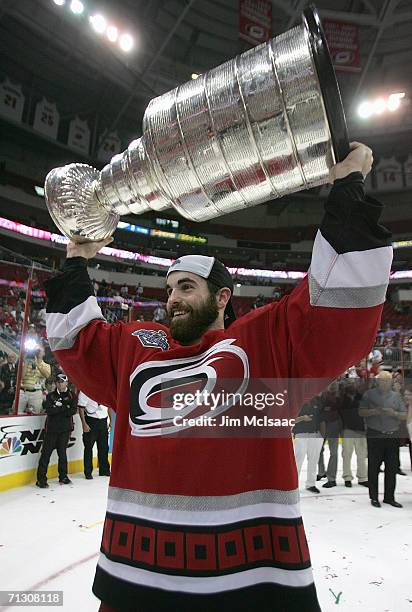Andrew Ladd of the Carolina Hurricanes hoists the Stanley Cup after the Hurricanes defeated the Edmonton Oilers in game seven of the 2006 NHL Stanley...