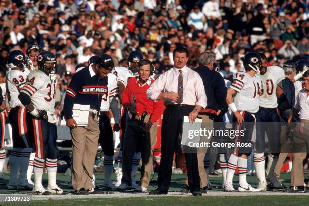 Running back Walter Payton, assistant coaches Johnny Roland, Vince Tobin and Head coach Mike Ditka of the Chicago Bears stand on the sidelines during...