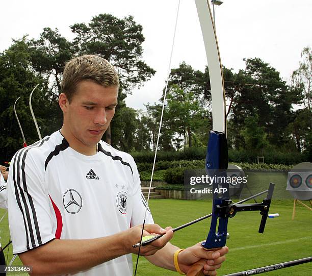 German forward Lukas Podolski prepares an arrow 28 June 2006 as the German national football team practices archery on a free morning in Berlin....