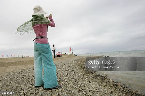 Tourist takes picture at the Qinghaihu Lake on June 27, 2006 in Qinghaihu Lake of Qinghai Province, China. The Qinghai-Tibet Railway, which will...