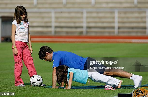 Juninho of Brazil does press ups with his daughters during the Brazil National Football Team training session for the FIFA World Cup Germany 2006 at...