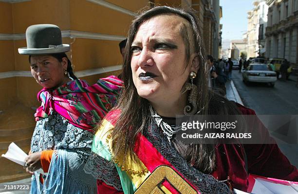 Maria Galindo candidata a asambleista por el colectivo de Diversidad Sexual y de Genero, camina por una calle de La Paz observada por una indigena...