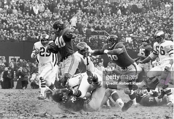 American professional football player Joe Morrison , of the New York Giants, rushes through the Philadelphia Eagles as teammates Jack Stroud, Phil...
