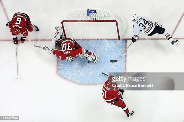 Goaltender Cam Ward of the Carolina Hurricanes makes a leg pad save on a shot attempt by Fernando Pisani of the Edmonton Oilers during game seven of...