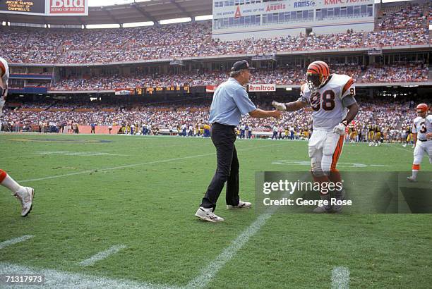 Head coach Sam Wyche of the Cincinnati Bengals greets David Grant as he walks to the sidelines during a game against the Los Angeles Rams at the...