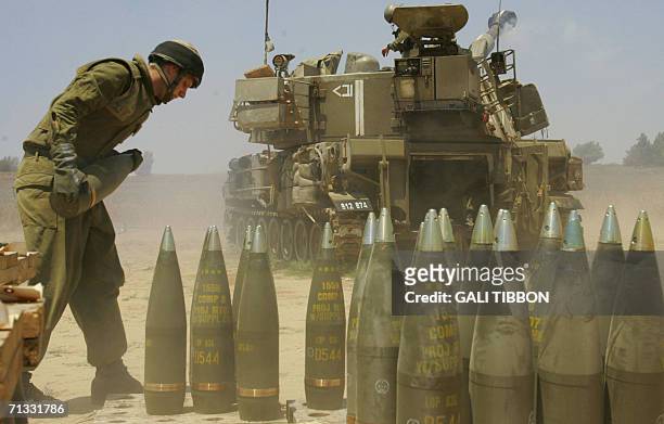 An Israeli soldier runs to reload an Israeli mobile artillery cannon after firing towards the Gaza Strip at a position near Kibbutz Nahal Oz, just...