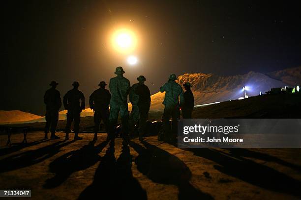 Army forward observers watch as an illumination round from an American 81mm mortar lights up the mountains near their outpost at Deh Afghan June 29,...
