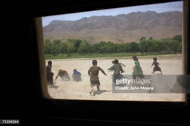 Afghan children race to pick up candy thrown to them by passing U.S. Soldiers near an American outpost at Deh Afghan June 29, 2006 in the Zabul...