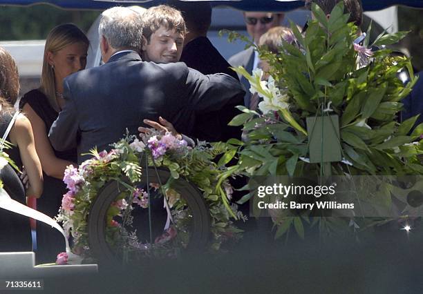 John Ramsey hugs his son Burke at the grave of JonBenet Ramsey after graveside service for his wife Patsy Ramsey June 29, 2006 in Marietta, Georgia....