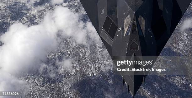 over new mexico - an f-117a nighthawk from holloman air force base, n.m. flies high over the mountains during a training mission. - f117 photos et images de collection