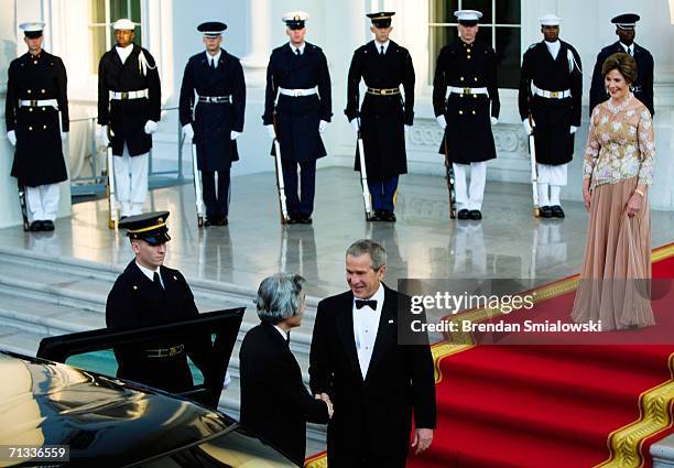 President George W Bush greets Japanese Prime Minister Junichiro Koizumi as first lady Laura Bush looks on at White House June 29, 2006 in...