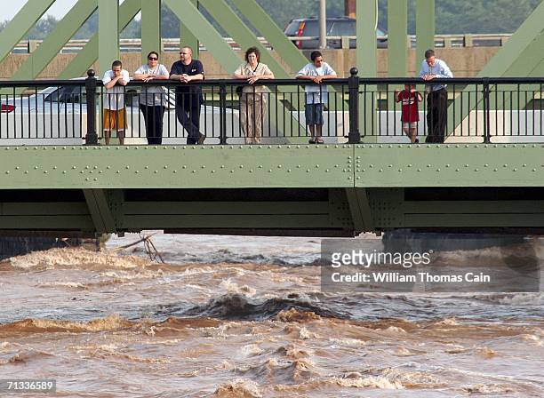 Spectators stand on bridge over the Delaware River and watch the flood waters rush past on June 29, 2006 in Trenton, New Jersey. Gov. Jon S. Corzine...