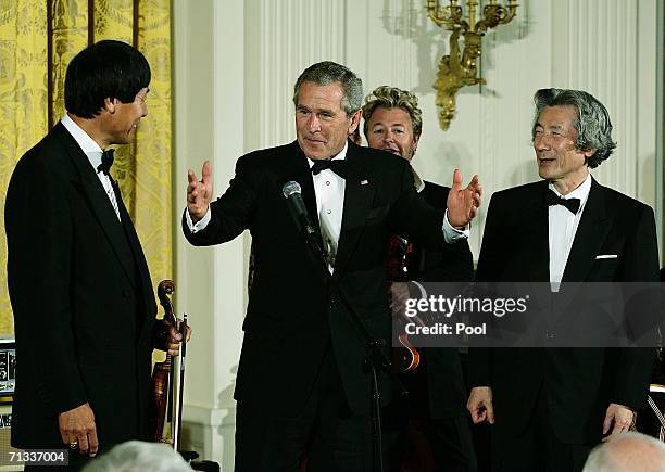 President George W. Bush thanks the Brian Setzer Orchestra and Shoji Tabuchi after they performed in the East Room of the White House June 29, 2006...