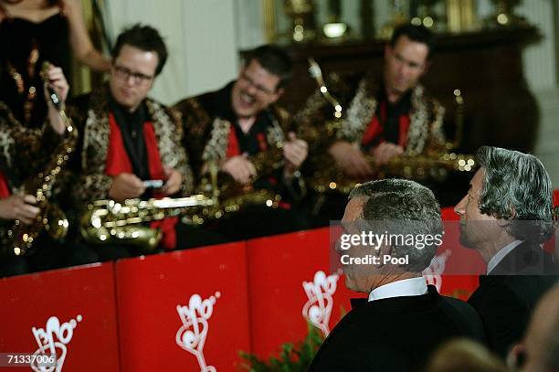 President George W. Bush and Japanese Prime Minister Junichiro Koizumi listen to the Brian Setzer Orchestra perform in the East Room of the White...